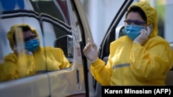 Բուժաշխատողը Երևանի «Սուրբ Գրիգոր Լուսավորիչ» բժշկական կենտրոնի դիմաց կանգնած շտապ բուժօգնության ավտոմեքենայի մոտ, արխիվ