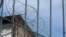 Птица на ограждении из колючей проволоки, возведенном по периметру тюрьмы.