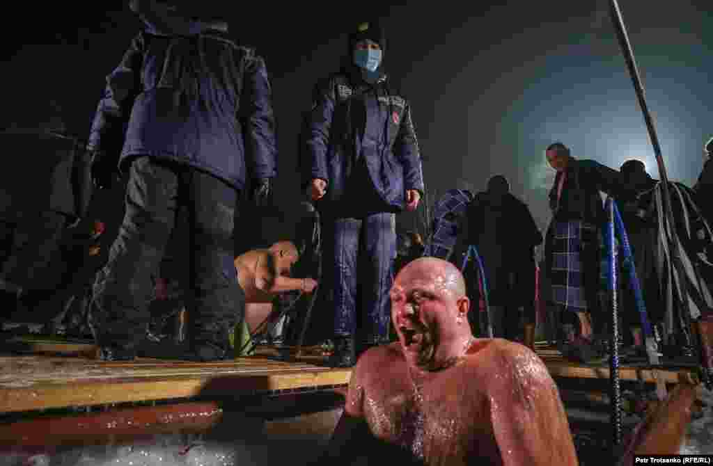 Чоловік виринає з крижаної води. Алмати, Казахстан