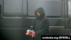 Невядомыя людзі раздаюць расейскія і беларускія сьцяжкі каля Акадэміі Навук у Менску