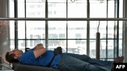 Italy - A passenger rests on his suitcases at Fiumicino airport near Rome, 19Apr2010 