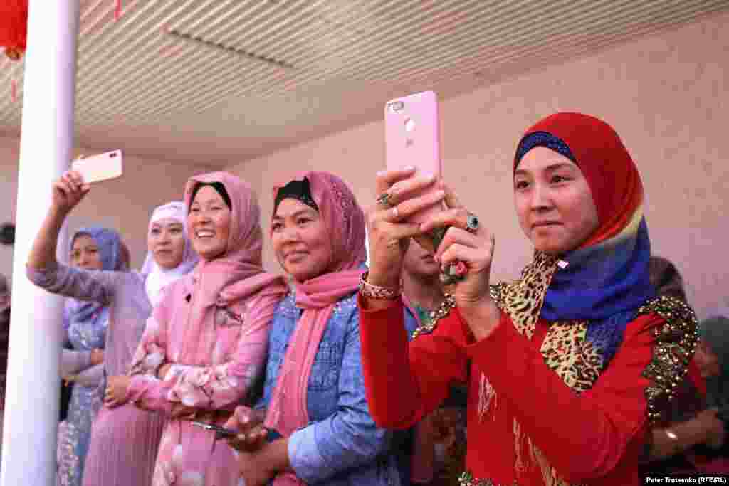 Дунганские девушки фотографируют невесту.