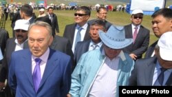 Nursoltan Nazarbaýew Gazagystanyň prezidenti wagtynda, öz kiçi dogany Bolat bilen barýar (Bolat onuň çep egninde).