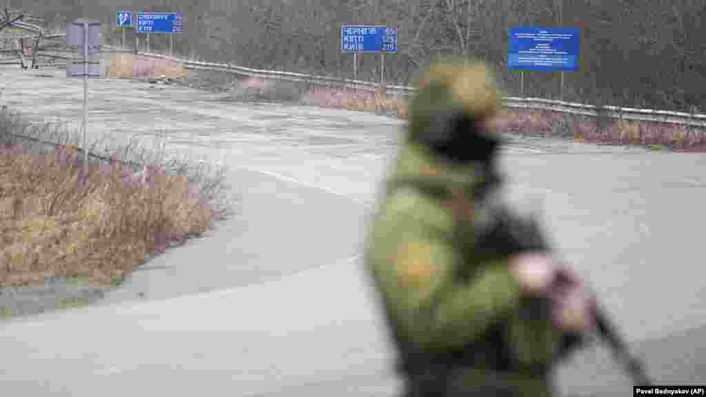 Белорусский пограничник с автоматом наблюдает за дорогой возле украинского пункта пропуска &laquo;Новые Яриловичи&raquo; в Гомельской области на границе с Украиной