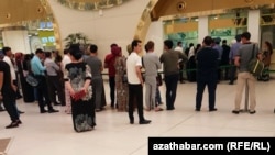 Ýolagçylar Aşgabadyň halkara howa menzilindäki bilet kassasynyň öňünde nobata garaşýar. Illýustrasiýa suraty. Arhiwden alyndy. 