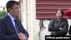 Samarqand viloyat hokimi Erkinjon Turdimov buzilishi rejalashtirilgan uy fonida Dilorom Roziqova bilan suhbatlashmoqda. 2019, oktabr.