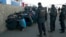 Russian police detain migrant workers during a raid on the Pokrovsky vegetable storage depot in the Biryulyovo district of Moscow on October 14, one day after the rioting sparked by the killing.