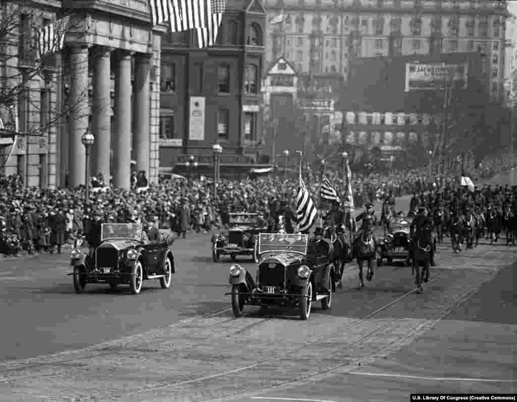 Президент Калвин Кулиж (алдыңкы машинада арткы орунда отурган жылаңбаш киши) экинчи инаугурациясы. 4-март, 1925-жыл. Анын кызматка киришүү аземи алгачкы жолу улуттук радиодон чагылдырылып, 23 миллиондой америкалык президенттин сөзүн түз обдо угуу мүмкүнчүлүгүн алган.&nbsp; &nbsp;