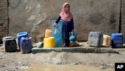Афғон қизалоқ Кобулдаги сув насосидан сув оляпти (архив).