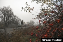 Украинский полицейский целится из винтовки во время угрозы удара российского FPV на пути к эвакуации гражданских из прифронтового города Гуляйполе. Запорожская область, 14 ноября 2025 года