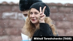 Maria Alyokhina flashes a V-sign as she arrives to attend a court hearing in Moscow in March.
