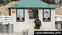 Ռուսաստանի նախագահ Վլադիմիր Պուտինի և Սիրիայի նախագահ Բաշար ալ-Ասադի նկարները Դամասկոսի արվարձանում՝ անցակետի պատին, 2018թ․