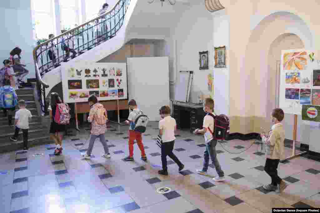 Медициналык текшерүүдөн өткөн балдар класска кирип бара жаткан учуру. Пандемияга байланыштуу Румынияда да мектептер эки жума кеч ачылды жана учурда окуучулардын жарымы мектепте окуса, калгандары аралыктан окуп жатат.&nbsp;