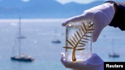 Організатори демонструють «Золоту пальмову гілку» перед початком 68-го Каннського фестивалю, 12 травня 2015 року