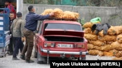 Покупатель грузит мешок картофеля на автомобиль на рынке «Сары-Озон». Бишкек, 11 октября 2018 года. Иллюстративное фото.