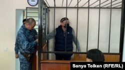 Обвиняемый в поддержке запрещенного в Казахстане движения «Демократический выбор Казахстана» (ДВК) Серик Жахин (в центре) в суде по его делу. 16 сентября 2019 года.