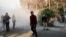 Участники антиправительственных протестов, для разгона которых применили дымовую гранату. Тегеран, 30 декабря 2017 года.