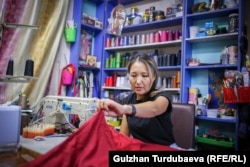 Бир жыл мурун Айнура кийим тигүү курсун аяктаган. Азыр кошунасынын цехине келип өзүнө көйнөк тигип жаткан учуру.