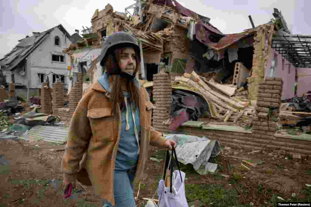 Тетяна Максименко виходить зі свого будинку, зруйнованого внаслідок російського ракетного удару під час масованого нападу Росії на Україну, Мархалівка, Київська область, 25 травня 2025 року