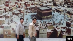 Иранда илинип турган "Мухаммед" тасмасынын жарнагынын жанында өтүп бараткан адамдар. Тегеран, Иран, 14-сентябрь, 2015-жыл  