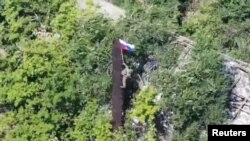 Ուկրաինա - Ռուս զինվորը ՌԴ դրոշն է բարձրացնում Դոնեցկի մարզում իրենց գրաված հերթական բնակավայրում, օգոստոս, 2025թ.