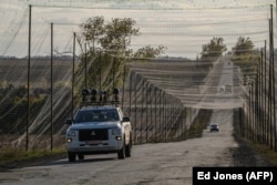 Автомобиль, оснащенный оборудованием для подавления сигналов, едет по дороге, покрытой противодронными сетками, на востоке Украины, 2 октября 2025 года