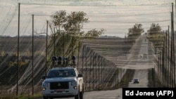 Сигналды басатын құрылғымен жабдықталған көлік тормен қорғалған жолда жүріп келеді. Украинаның шығыс бөлігі, 2 қазан