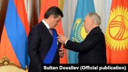 Нурсултон Назарбоев қирғиз президенти Сўўрўнбай Жээнбековга орден топширмоқда.