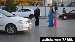 Aşgabatda ýoldan geçip barýan aýal-gyzlar.