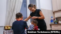 Айнура балдарына кечки тамагын берип жатат.