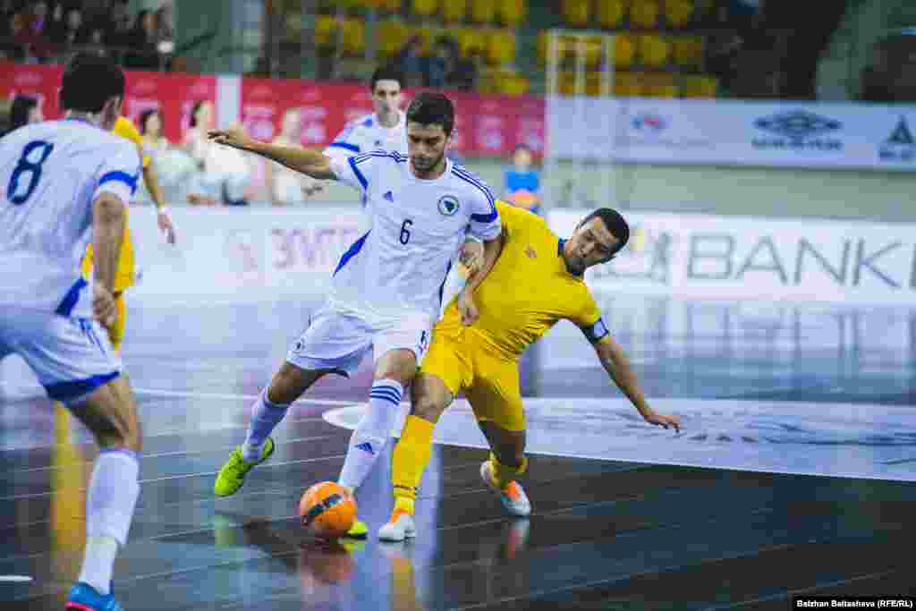Казахстанская сборная в ответном матче во Дворце спорта имени Балуана Шолака победила команду из Боснии и Герцеговины со счетом 4 : 0. Во время первой встречи на прошлой неделе в Боснии и Герцеговине казахстанцы тоже одержали победу - 5 : 0. На фото: капитан казахстанской команды Динмухаммед Сулейменов (в желтой форме) ведет борьбу за мяч.&nbsp;