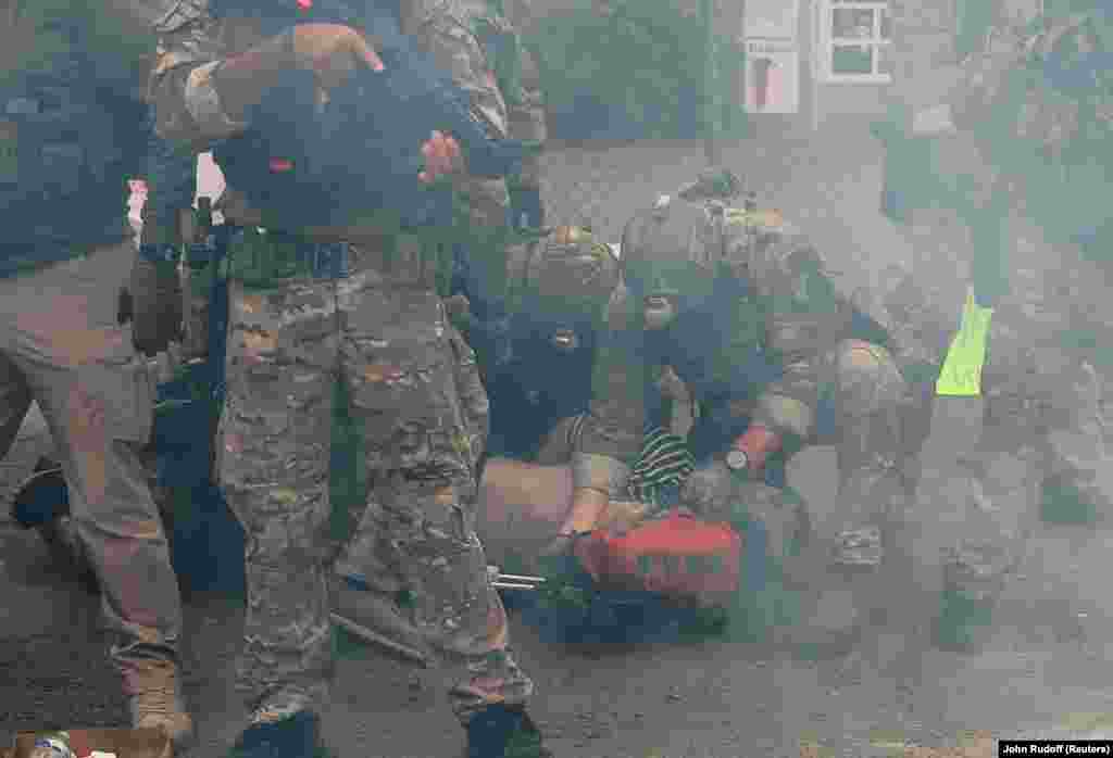 Правоохоронці затримують людину біля будівлі ICE (Міграційна та митна правоохоронна служба США) під час акції протесту «Ні королям» проти політики президента США Дональда Трампа. Портленд, штат Орегон, США, 18 жовтня 2025 року