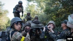 Українські військовослужбовці несуть пораненого під час бойових дій під Іловайськом, серпень 2014 року