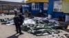 A Ukrainian policeman bends over the bodies of civilians killed in a Russian missile strike on a railway station in Kramatorsk in April 2022. 
