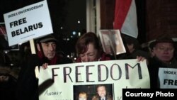 Сястра Андрэя Саньнікава Ірэна Багданава з плякатам падчас акцыі пратэсту перад амбасадай Беларусі ў Лёндане 21 сьнежня 2010 году