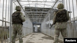 Өзбек чек арачылары кыргыз-өзбек чегиндеги көпүрөдө. Кара-Суу, 16-июнь, 2010. (Сүрөттүн азыркы окуяга тиешеси жок.)