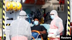 فرد مبتلا به ویروس کرونا از سوی تیم صحی ایتالیا در حال انتقال به شفاخانه