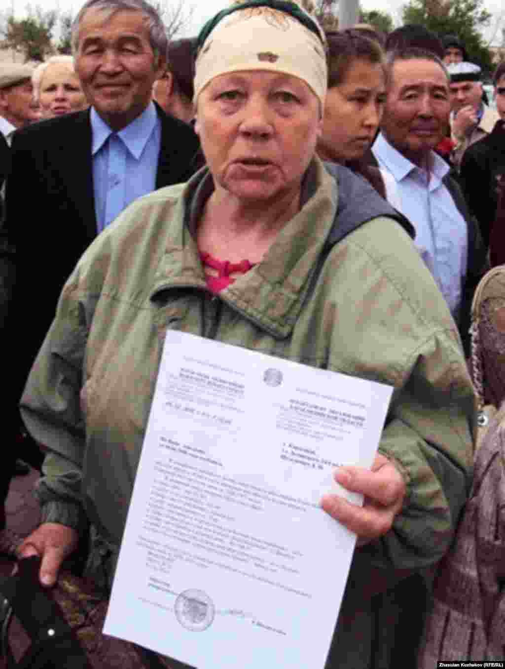 Казакстандын Караганды облусунун Долинка жергесинде саясий куугунтук жана сүргүн курмандыктарынын музейинин ачылыш аземине келген коноктордун бири, мурдагы туткун Лидия Шультевич өзүнүн акталганы тууралуу кагазды кармап турат.  31.5.11.