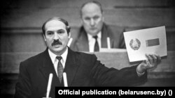 Лукашэнка дэманструе ўзор новай сымболікі дэпутатам Вярхоўнага Савету. Красавік 1995 году
