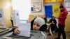Ребенок голосует за родственника во время президентских выборов и референдума о вступлении в ЕС на избирательном участке для жителей Приднестровского региона в Варнице 