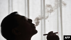 Электрондук чылымдын ойлоп-табуучусу кытайлык фрмацевт Хон Лик жасалма тамекини Бээжинде даңазалап көрсөтүүдө. 25 -март 2009 