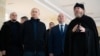 Russian President Vladimir Putin (second left), Sevastopol's Russian-imposed Governor Mikhail Razvozhayev (center), and Metropolitan Tikhon (right), chairman of the Patriarchal Council for Culture, visit a children's center in Sevastopol, Crimea, on March 18.