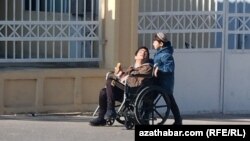 Mümkinçiligi çäkli adamyň maýyp arabasyny itip barýan çaga (Illýustrasiýa suraty)