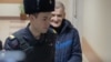 Yury Dmitriyev is escorted to a court hearing in 2019.
