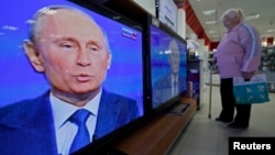 Кибеттәге бер ханым Путин чыгышын күзәтә