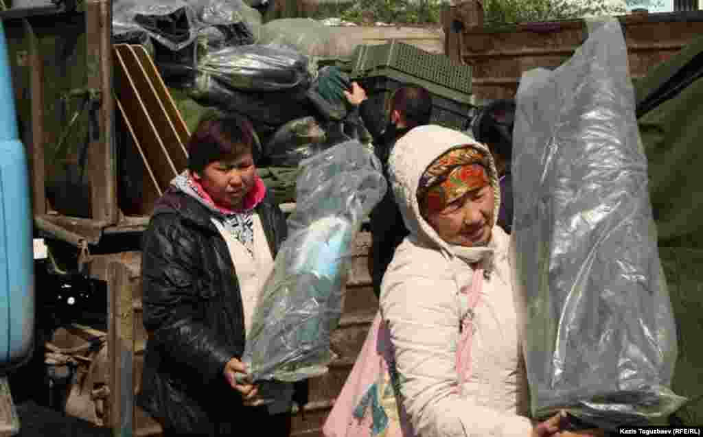 Погорельцы выгружают вещи, привезенные им службой спасения.