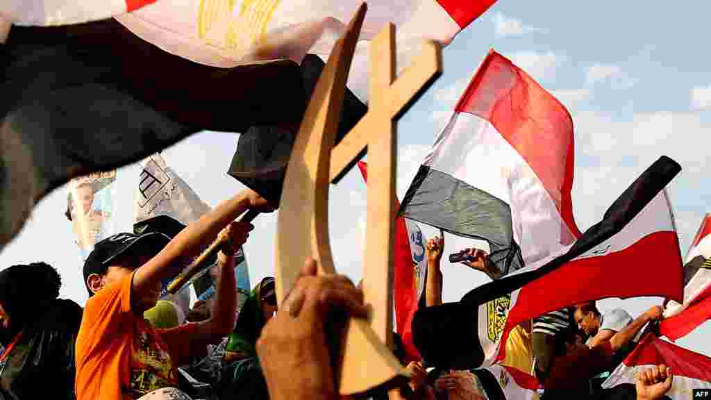 Ахмед Шафиктин жактоочулары христиан жана мусулман эн белгилерин айкалыштырып кармап турат.&nbsp; Каир, 23.06.2012 