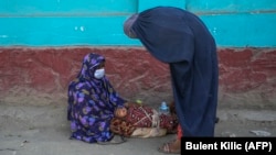 آرشیف، یک گدای زن همراه با کودکش در یک از جاده های شهر کابل