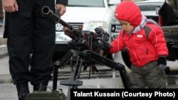 Ребенок рассматривает пулемет, выставленный на показе вооружения. Актау, 13 апреля 2013 года. 