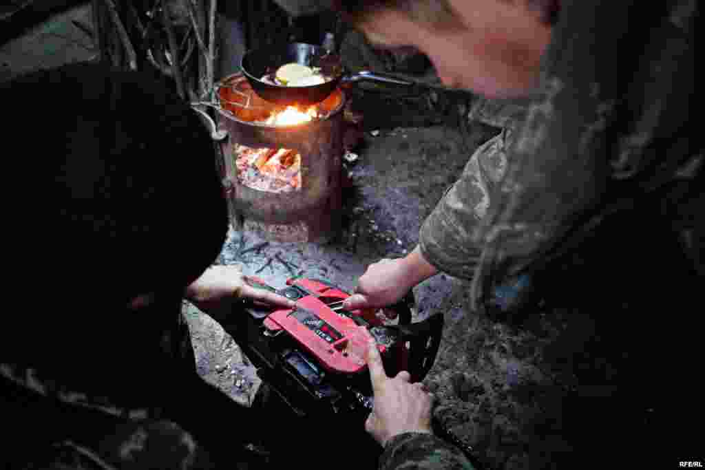 Військові лагодять свою бензопилу. Вони мусять готувати деревину, щоб забезпечити передову необхідним паливом для обігріву бліндажів